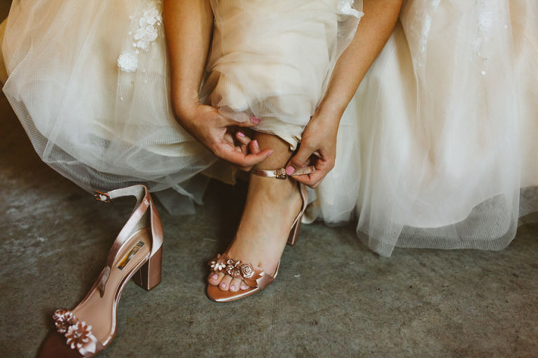 bride getting shoes on 