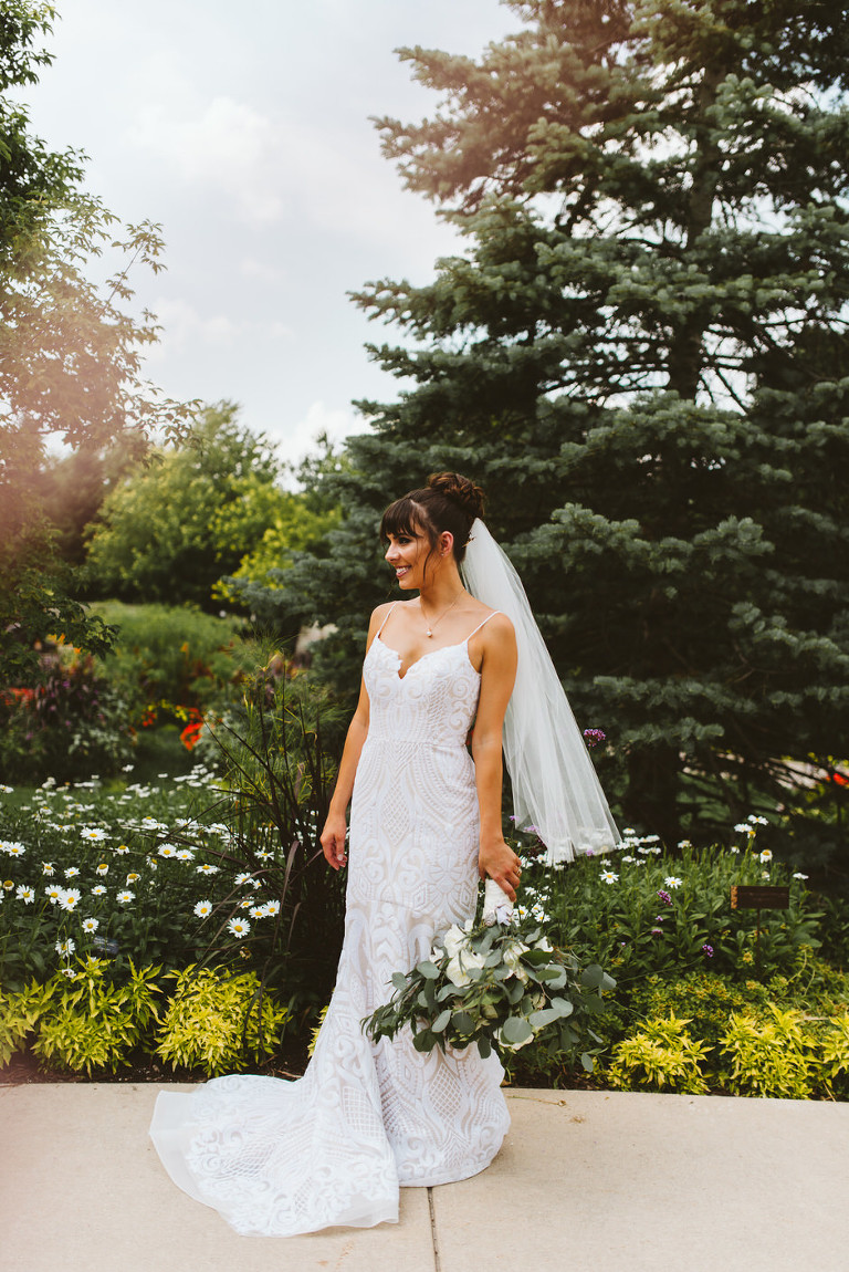 photo of bride at fredrick meijer gardens posing with bouquet and looking to the right 