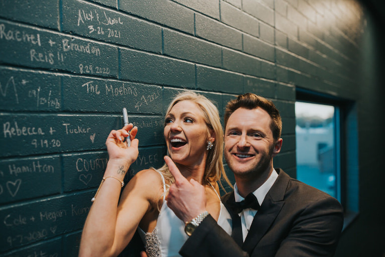 couple in front of the wall in Port 393 that has all the signatures and dates of every couple married there! i love this idea and as a photographer capturing memories even if just written is so important!