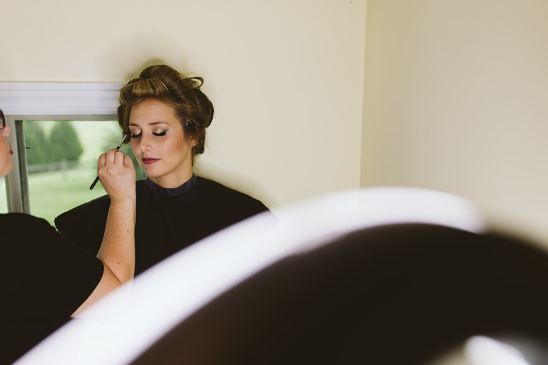 bride having makeup applied a ring light in the foreground