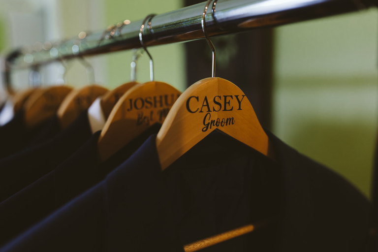 close up of mens suit hangers with names on tehm