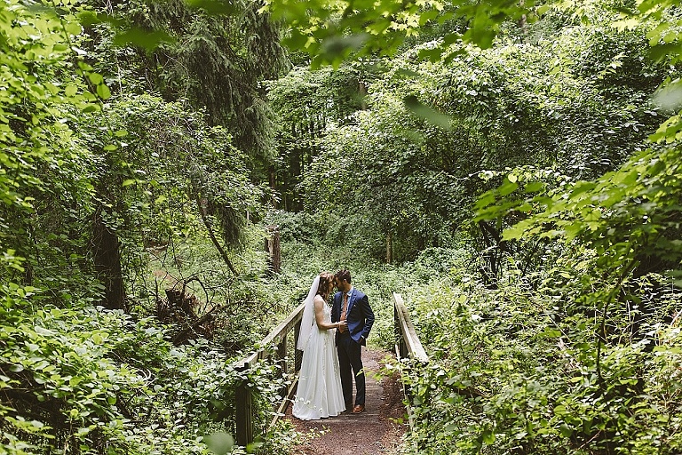 Bride and groom walking through the forest at Fenner Nature Center wedding